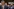 Hegseth, hinter im ein Protestschild mit der Aufschrift 