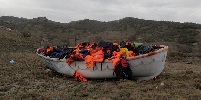 Ein Boot mit orangenen Schutzwesten steht auf einer Wiese.