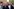 Özgur Ozel (rechts) steht mit anderen Männern vor einem Gebäude, alle haben einen ernsten Gesichtsausdruck