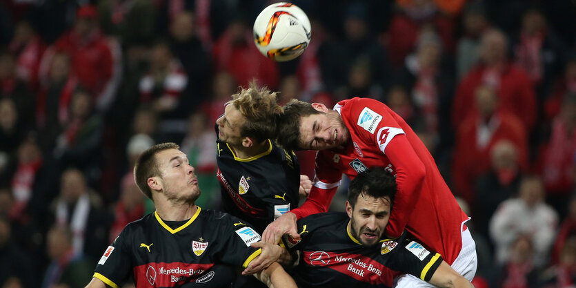 Fußballer springen in die Luft, um den Ball zu bekommen.