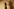 Ein Frau steht ängstlich vor einer Wand und rechts ein großer Schatten einer anderen Person
