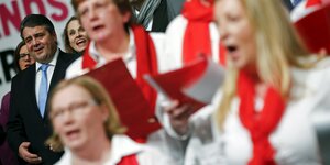 Sigmar Gabriel singt, neben ihm ein Chor mit roten Halstüchern