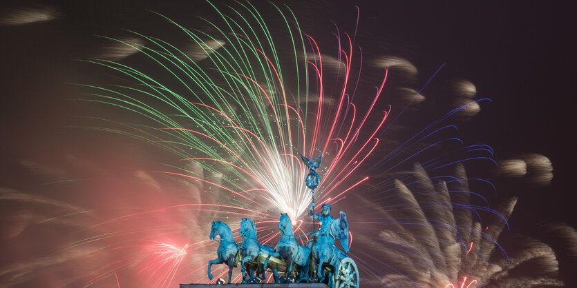 Silvesterfeuerwerk leuchtet über dem Brandenburger Tor