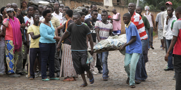 Menschen in der burundischen Hauptstadt bergen eine verdeckte Leiche.