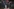 Antifaschist:innen mit Antifa-Fahnen hinter einer mobilen Absperrung bei einer Demonstration gegen die AfD. Viele von ihnen sind vermummt, ein halbes Dutzend Polizeibeamte stehen ihnen vor der Absperrung nah gegenüber.