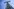 Ein Strommast hinter Zaun und Nato-Stacheldraht