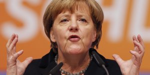 Angela Merkel im Porträt mit erhobenen Händen