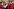 Filmszene, Männer in roten Fantasieuniformen, im Hintergrund eine Frau nehmen sich Sekt von einem Silbertablett