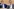Baden-Württembergs Innenminister Manuel Hagel (CDU) und Ministerpräsident Cem Özdemir (Bündnis 90/Die Grünen) sitzen im Landtag vor hölzernen Wänden nebeneinander. Beide haben die rechte Hand am Mund, lehnen sich zurück und schauen auf das Geschehen mit demselben neutralen Gesichtsausdruck. Hinter ihnen sitzt Landesfinanzminister Danyal mit Blick nach unten.