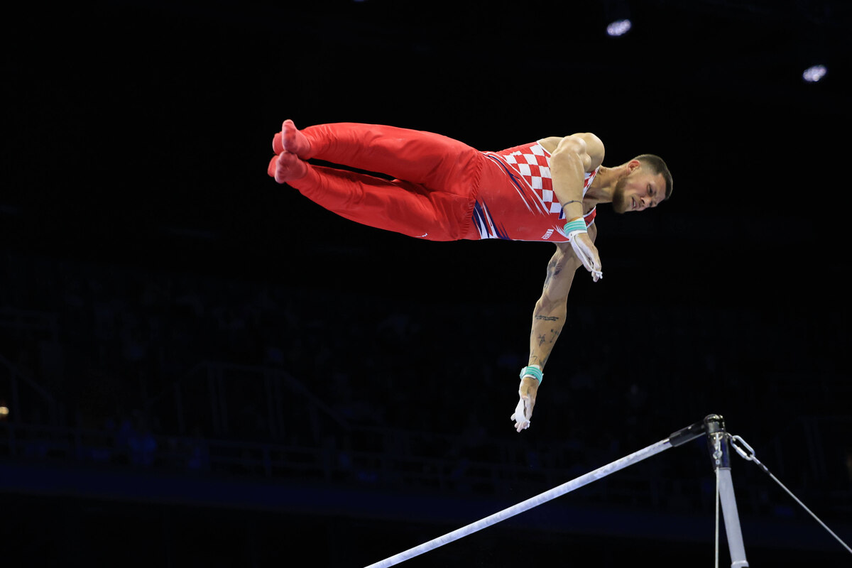 Turner Kovtun fliegt über dem Reck durch die Luft