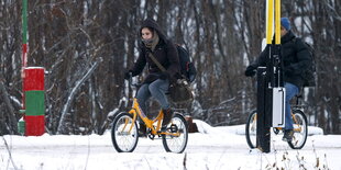 lüchtlinge auf dem Fahrrad an der norwegisch-russischen Grenze.