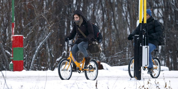 lüchtlinge auf dem Fahrrad an der norwegisch-russischen Grenze.