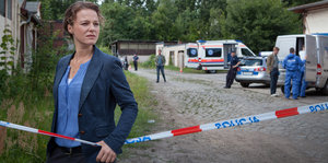 Filmstill aus einem Polizeiruf: eine Frau steht hinter polnisch beschrifteten Absperrband
