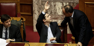 Griechenlands Premierminister Tsipras sitzt im Parlament und hebt die rechte Hand bei einer Abstimmung