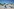 Viele Menschen sitzen mit oder ohne Sonnenschutz am Strand von Tel Aviv