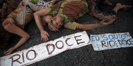 Aktivisten liegen hinter einem Transparent auf dem steht: „Ich bin der Rio Doce“