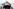 Mann in schwarzer Jacke mit Kappe von unten fotografiert, steht vor Reichstagsgebäude