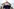 Mann in schwarzer Jacke mit Kappe von unten fotografiert, steht vor Reichstagsgebäude