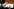 Eine Person hält ein Mikrofon von „Ongehoord Nederland“ während einer Pressekonferenz von Rianne Letschert, Ministerin für Bildung, Kultur und Wissenschaft, zum Sender „Ongehoord Nederland ON“