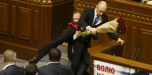Ein aufgebrachter Abgeordneter versucht Regierungschef Arsenij Jazenjuk aus dem Parlament zu befördern.