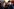 Die Regisseure Rachel Szor und Yuval Abraham - im Hintergrund sind unscharf Fotograf*innen und Journalist*innen zu erkennen. Sie schauen beide ernst in die Kamera