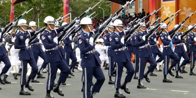Taiwanesische Soldaten halten bei einer Militärparade ihre Gewehre hoch