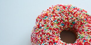 Ein Donut mit bunten Streuseln