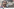 Mensch mit kurzen dunklen Haaren und Bart steht in Aufzug, im Hintergrund Sticker der taz und gegen die AfD