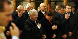 Mehrere Männer und eine Frau beten in einer Kirche
