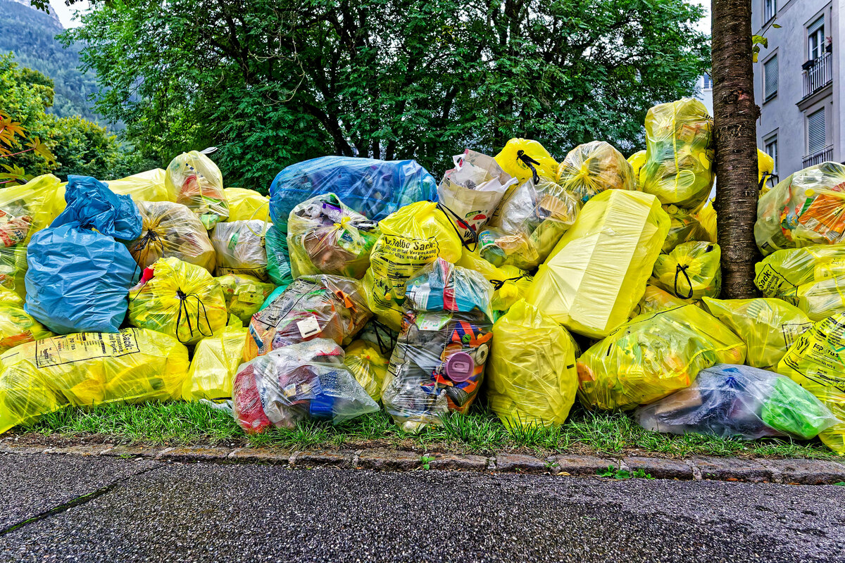 Gelbe und blaue Säcke voller Plastikmüll