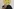 Eine unbekannte Person hält sich eine Maske vor das Gesicht, die wie ein wütendes Emoji aussieht