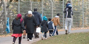 Geflüchtete laufen einen Weg entlang.