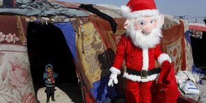 Weihnachtsmann und Kleinkind vor einem Zelt