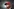 Donald Trump mit roter Kappe vor einem schwarzen Hintergrund