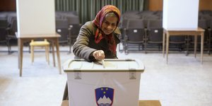 Eine ältere Frau an einer Wahlurne in Slowenien