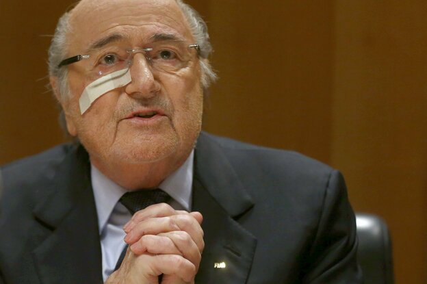 Sepp Blatter hält seine verschränkten Hände hoch, ein Pflaster klebt auf seiner Backe