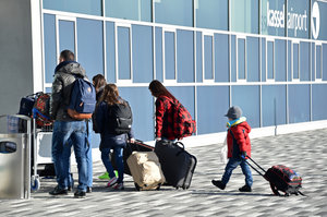 Menschen gehen mit Koffer in einen Flughafen