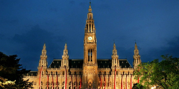 beleuchtetes Wiener Rathaus vor dunklem Himmel