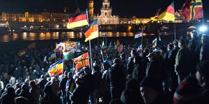 Pegida-Anhänger vor der erleuchteten Kulisse der Dresdner Altstadt