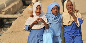 Drei Mädchen gehen in Nigeria zur Schule