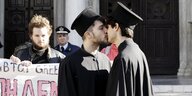 Aktivisten, verkleidet als griechisch-orthodoxe Priester, küssen sich während einer Protestaktion gegen Homophobie außerhalb der Athener Kathedrale.