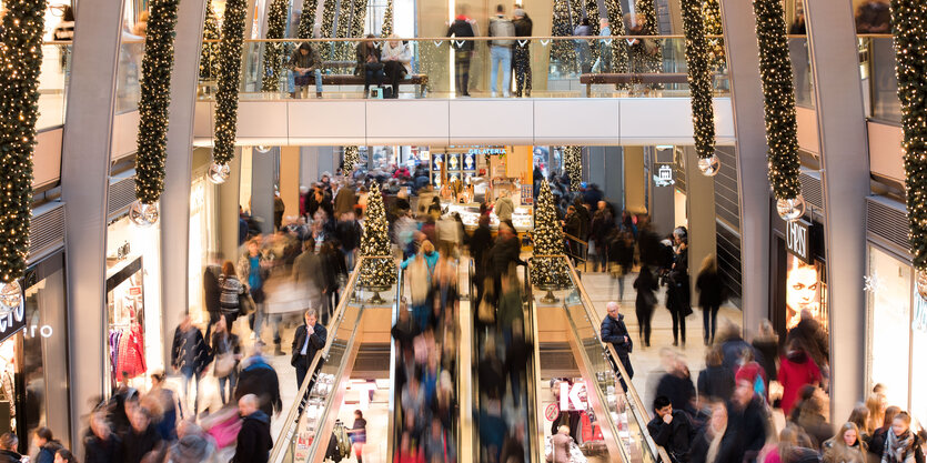 Viele Menschen in einem Shoppingcenter mit Weihnachtsbeleuchtung