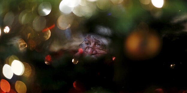 Ein Weihnachtsmann versteckt hinter Bäumen
