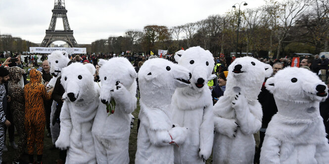 In Paris versammeln sich Protestler in Eisbärenkostümen vor dem Eiffelturm.