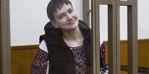 Nadeschda Sawtschenko, eine Frau mit kurzen Haaren, in einer Zelle in einem Gerichtssaal