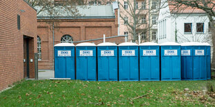 Toilettenhäuschen vor einer Turnhalle