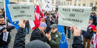 Demonstranten halten Plakate in die Höhe