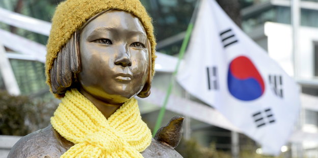 Bronzedenkmal eines Mädchens mit gelber Mütze und Wollschal