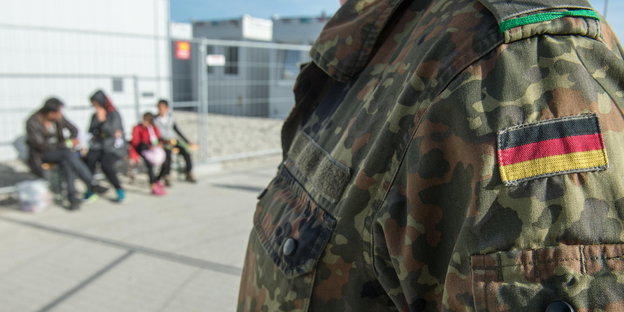Ein Bundeswehrsoldat steht im Wartezentrum Asyl in Erding (Bayern) vor Flüchtlingen