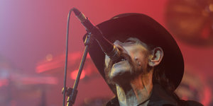 Lemmy Kilmister singt in rotes Licht getaucht in ein Mikrofon